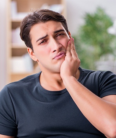 Man in pain holding jaw before root canal therapy