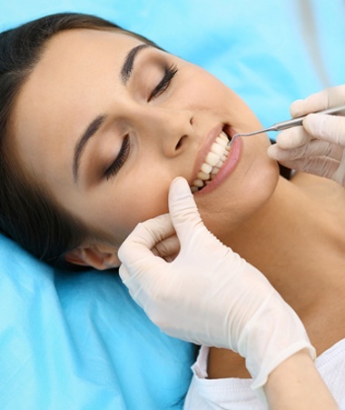 Dentist checking patient's smile after porcelain veneer placement
