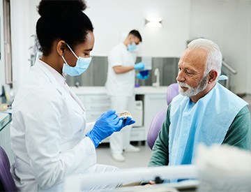 A dentists explaining denture materials to an older man