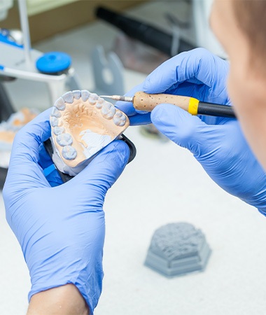 A lab technician working on dentures