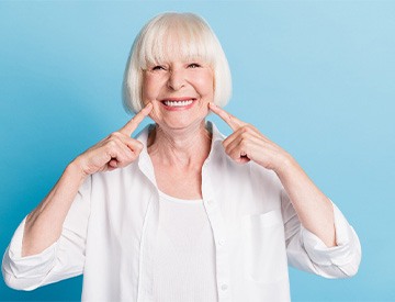 A smiling older woman adjusting to her dentures